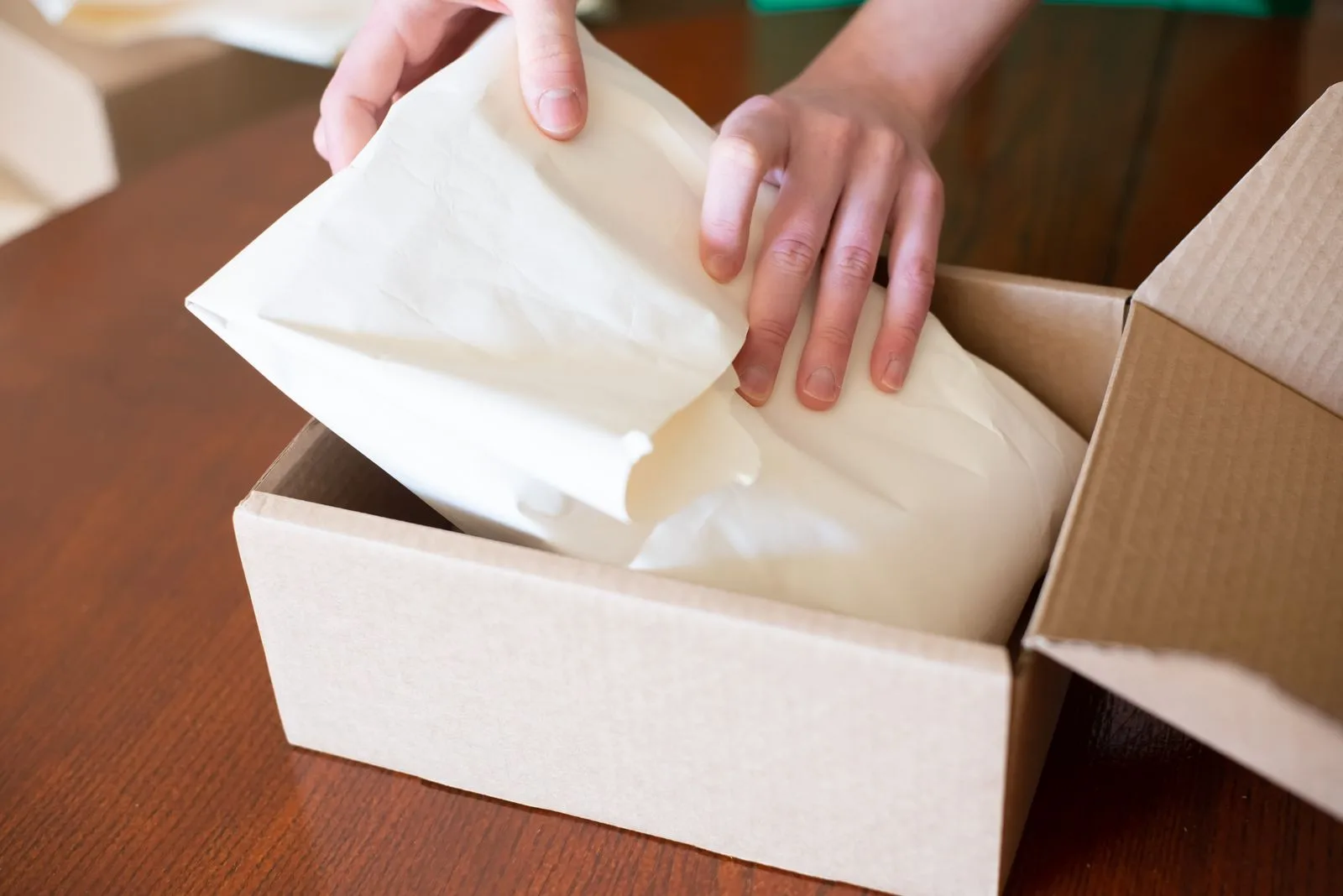 Hands packing a boutique retail order into a box
